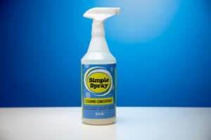 A 32 fluid oz bottle of the Simple Spray Multipurpose Cleaning Concentrate by The Simple Scrub, the perfect spray for cleaning glass shower doors.