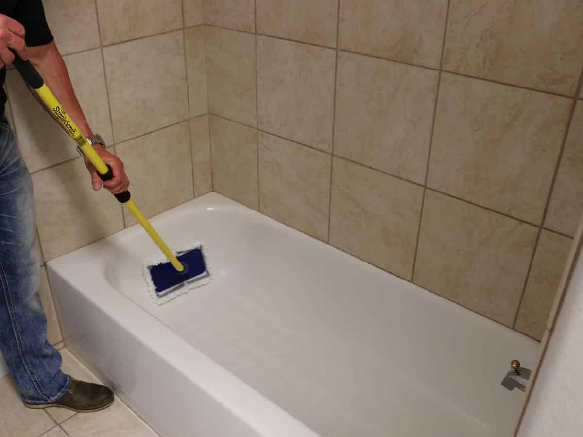 Man cleaning bathtub with The Simple Scrub Original.