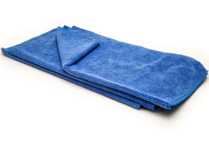 A stack of 3 dark blue microfiber cloths available for purchase on The Simple Scrub website.